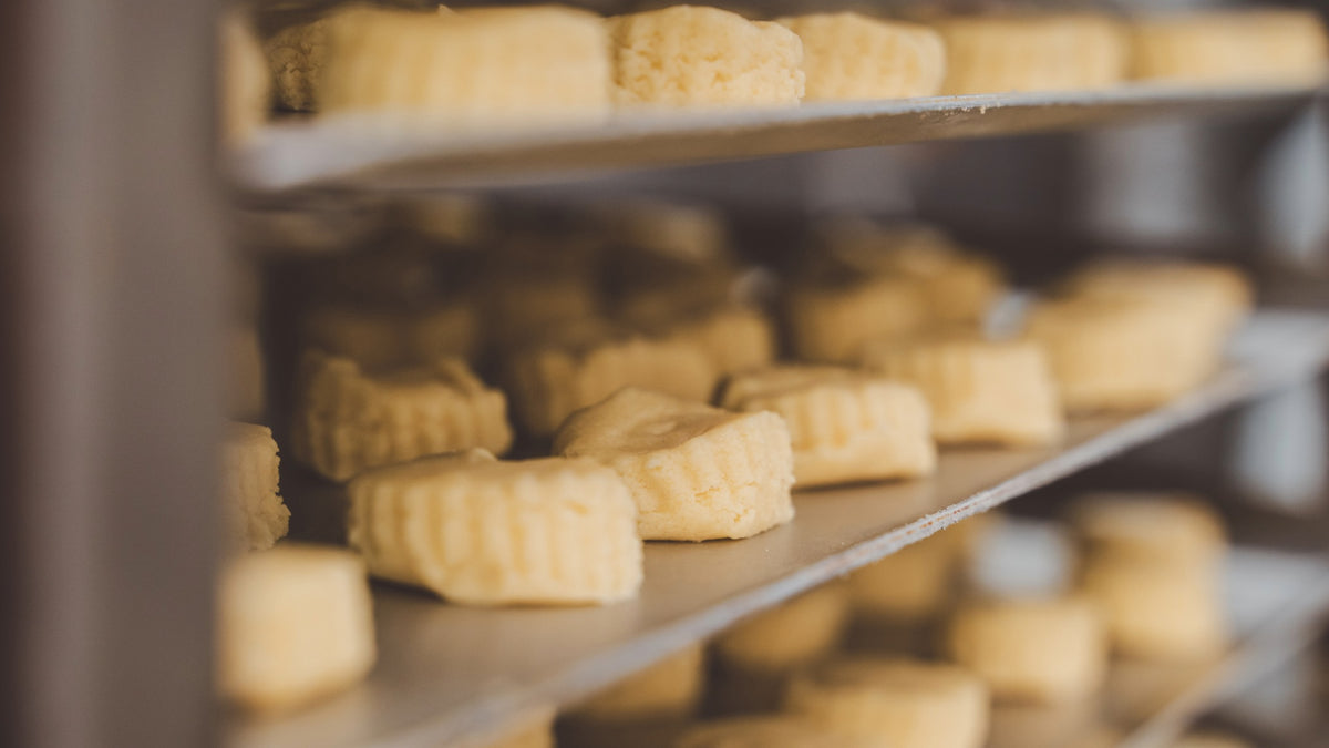 Unbaked shortbread biscuits on a metal tray.
