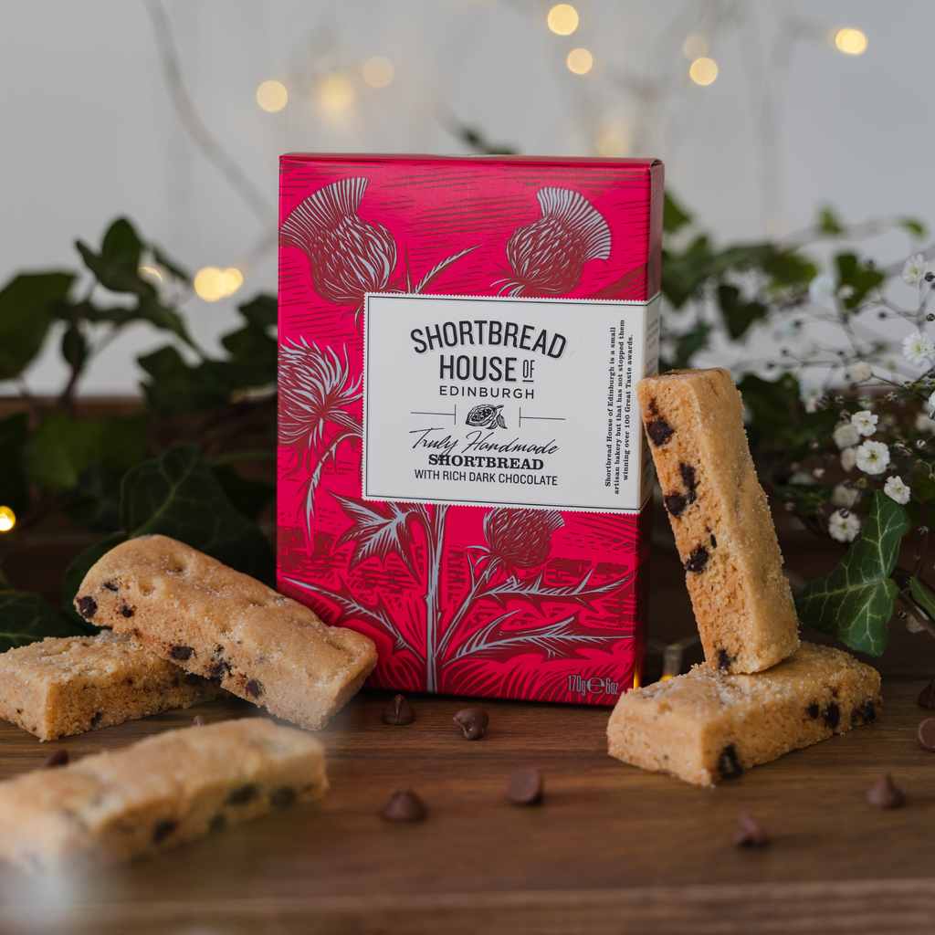 Shortbread house Edinburgh shortbread with rich dark chocolate on a wooden surface with a pink packaging box.