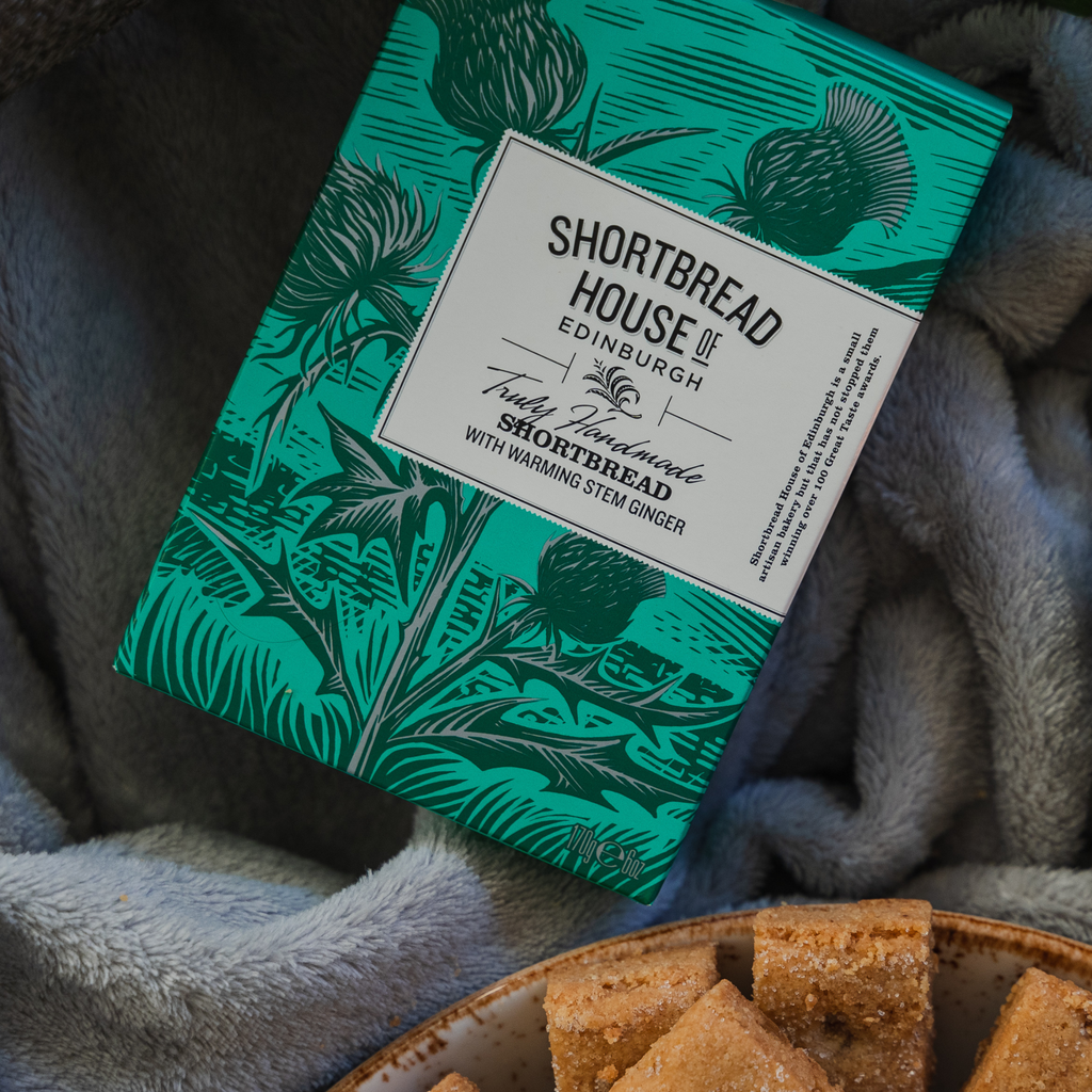 Box of Shortbread House Edinburgh shortbread on a soft fabric background with some shortbread fingers. 