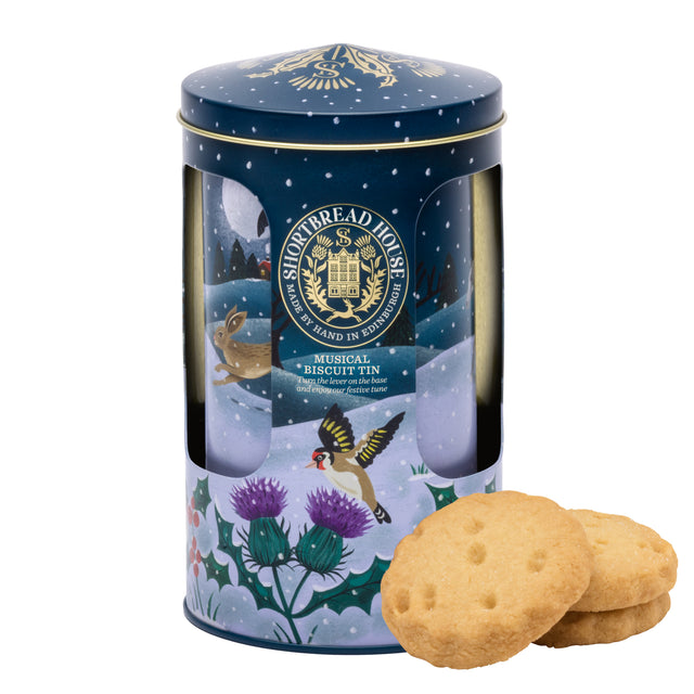 Decorative musical biscuit tin with a lid featuring illustrations of birds and plants, accompanied by two biscuits on a white background.