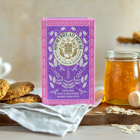 Box of Heather Honey Oaties with a jar of honey and biscuits on a wooden board.