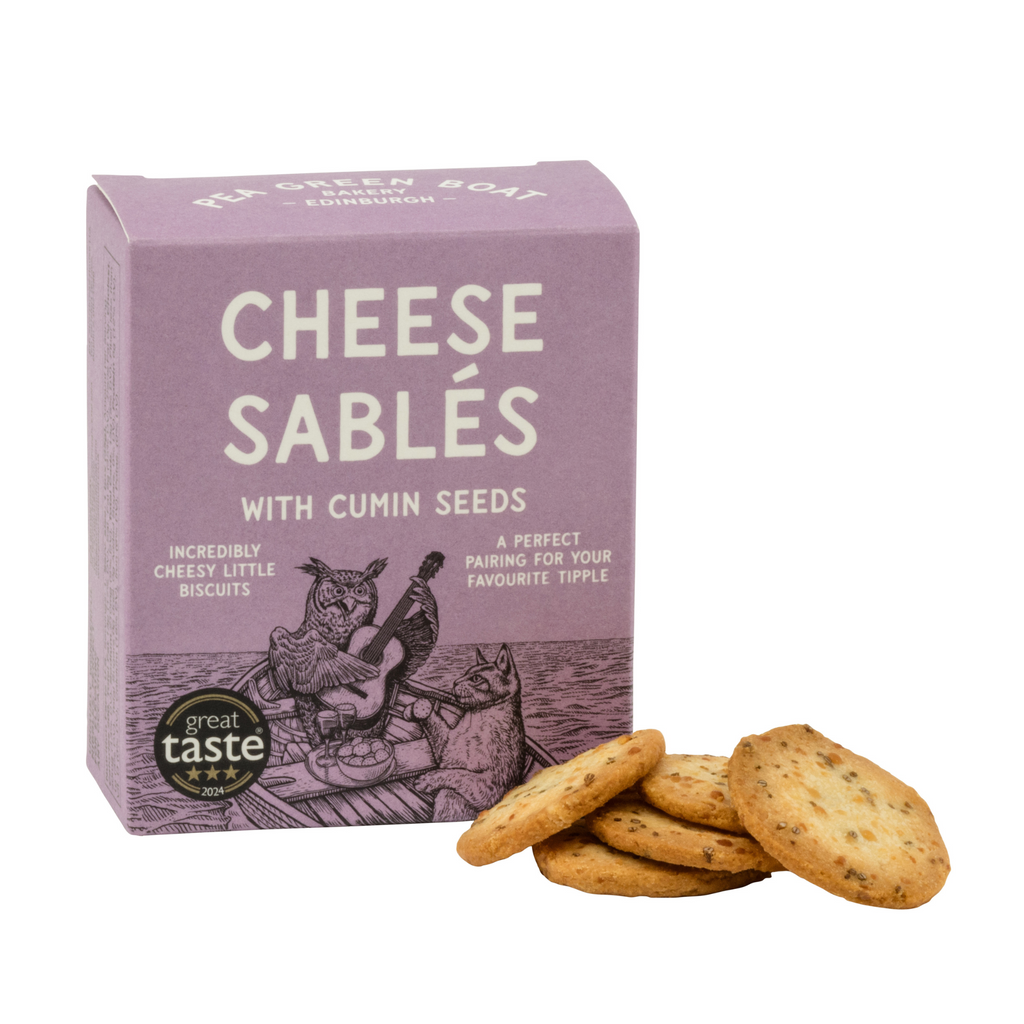 Small purple box of Cumin Cheese Sables with biscuits stacked to the side.