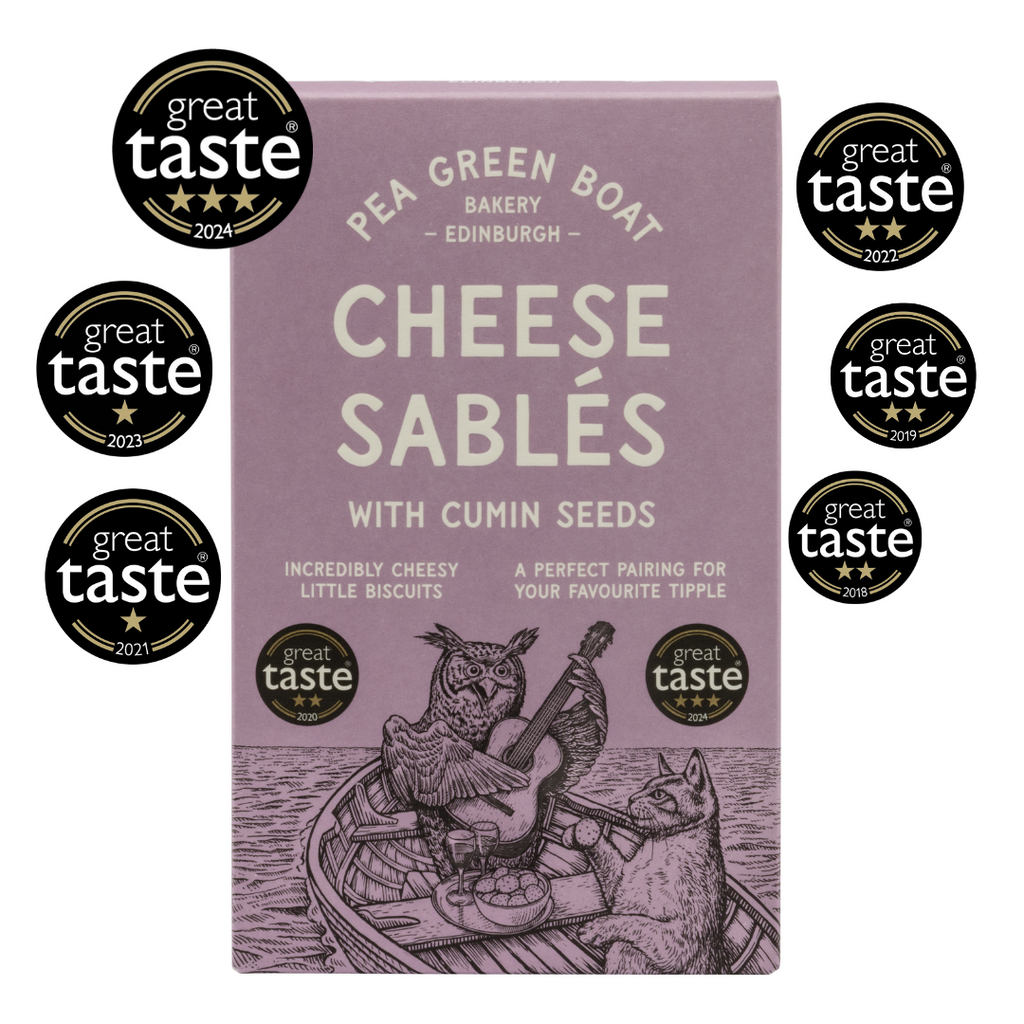 Purple box of cumin cheese sables with 6 Great Taste Awards around it