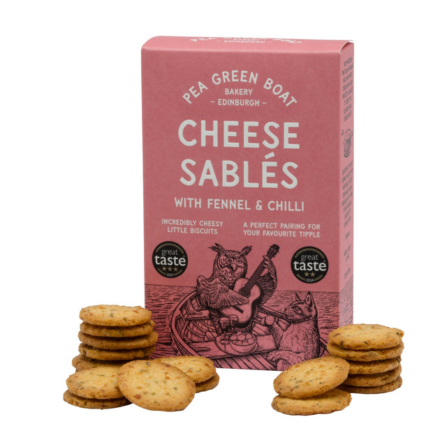 Box of Pea Green Boat Bakery Cheese Sablés with fennel and chilli, surrounded by cookies on a white background