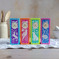 Four colorful tea boxes with animal illustrations on a wooden surface.