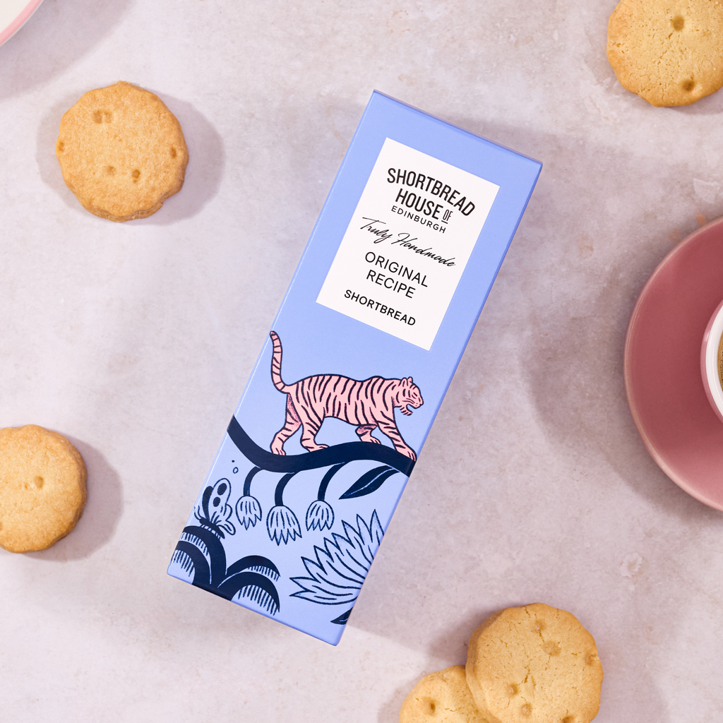 Shortbread box with tiger design on a surface with round biscuits