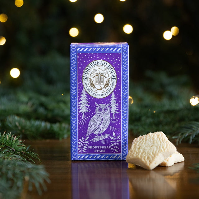 Purple Box of Shortbread Stars with Owl Design amongst Fir Branches